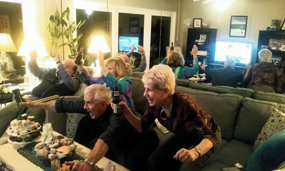 Baby boomers dans leurs grande maison en train de regarder un match