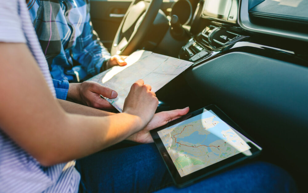 Couple comparing paper map and a gps navigator